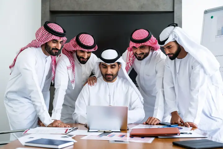 فريق شركة سعودية يراجع العرض على اللابتوب